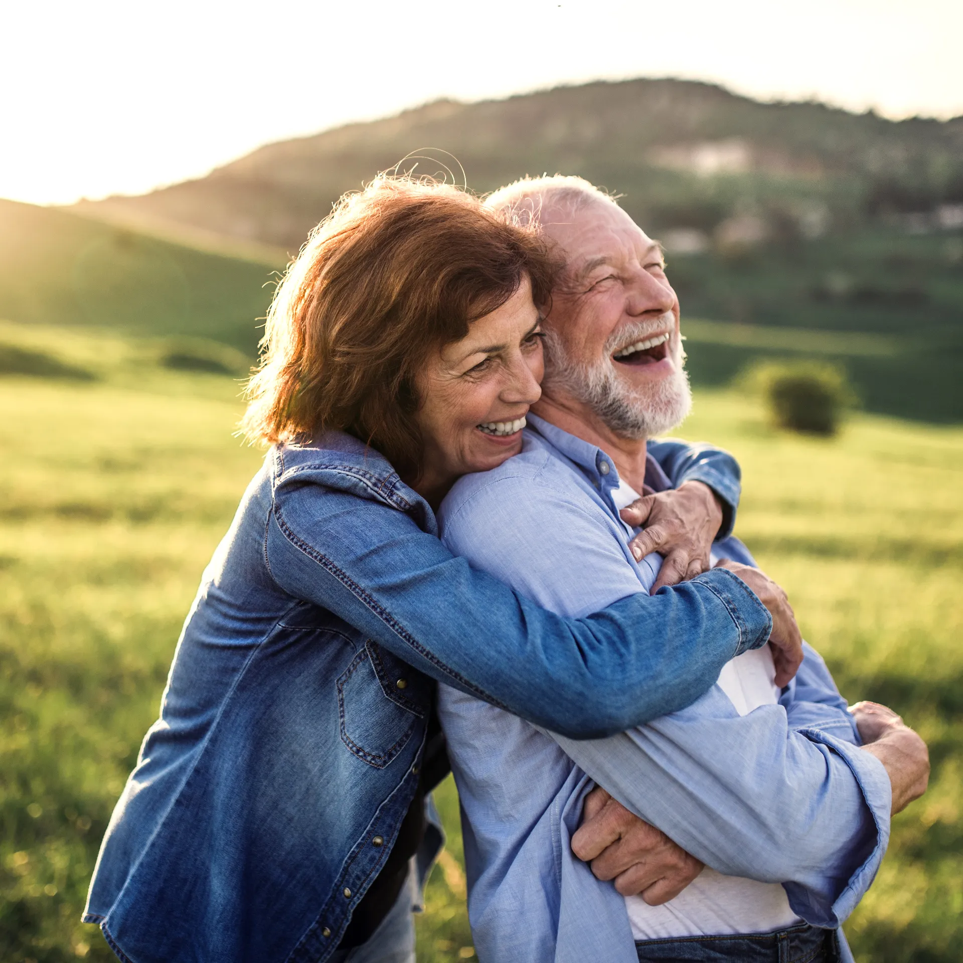 Un couple âgé enlacé en plein air.