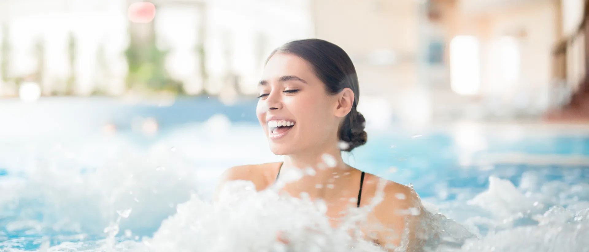 Lachende Frau im Wasser einer Therme