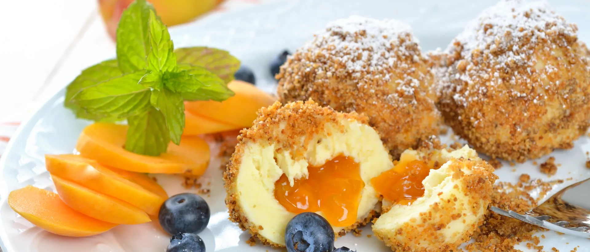 Marillenknödel mit Heidelbeeren auf einem Teller.
