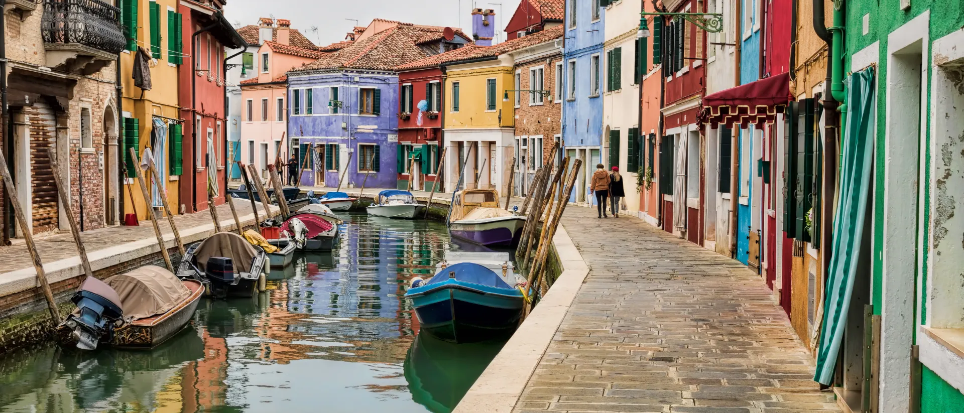 Kanal in Burano mit Booten und bunten Häuserfassaden.