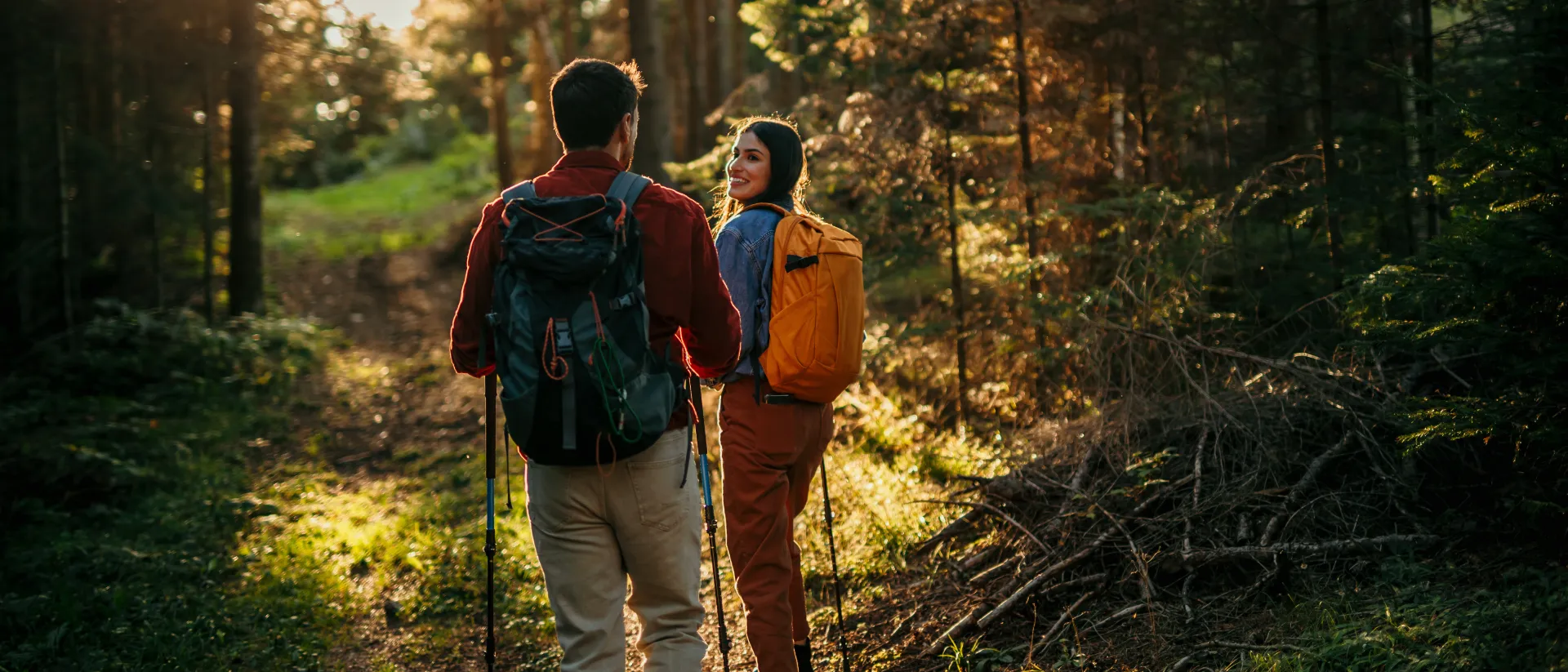 Paar am Wandern in einem Wald bei Sonnenuntergang