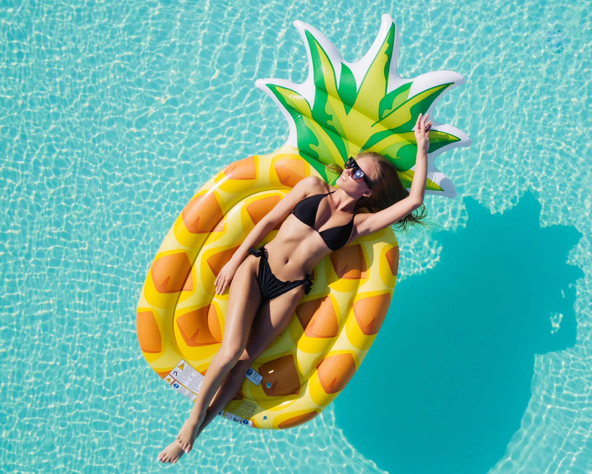 Frau entspannt auf einer Luftmatratze in einem Pool