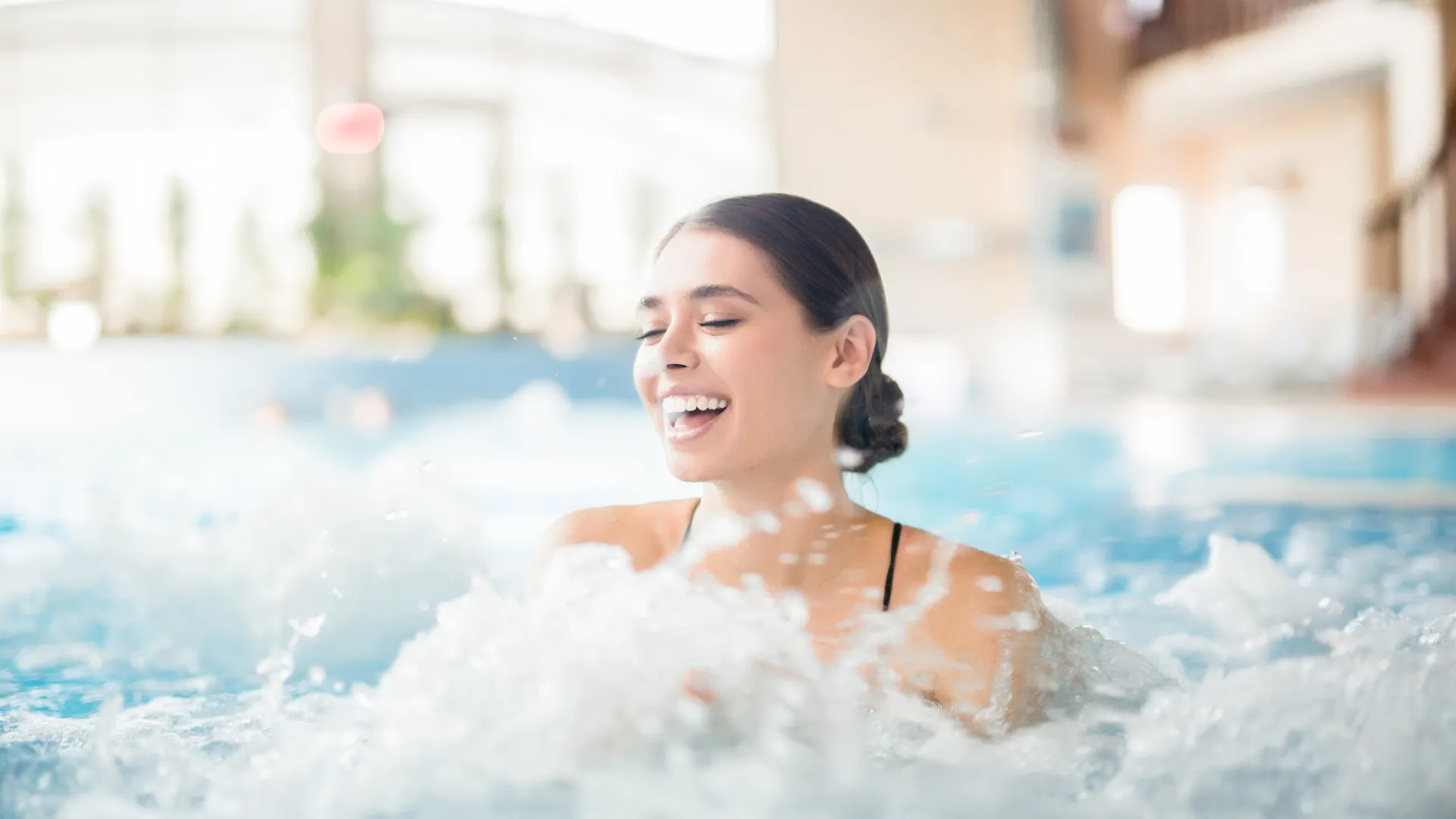 Lachende Frau im Wasser einer Therme