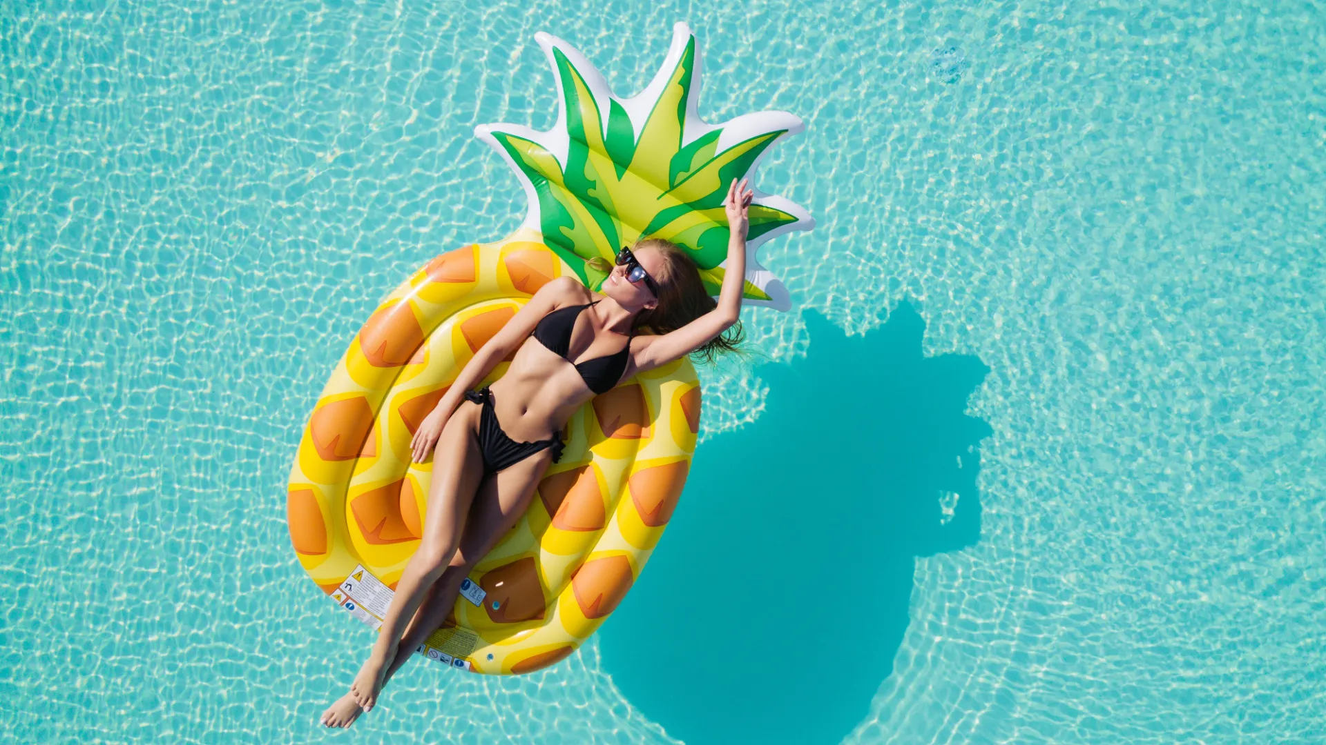 Frau entspannt auf einer Luftmatratze in einem Pool