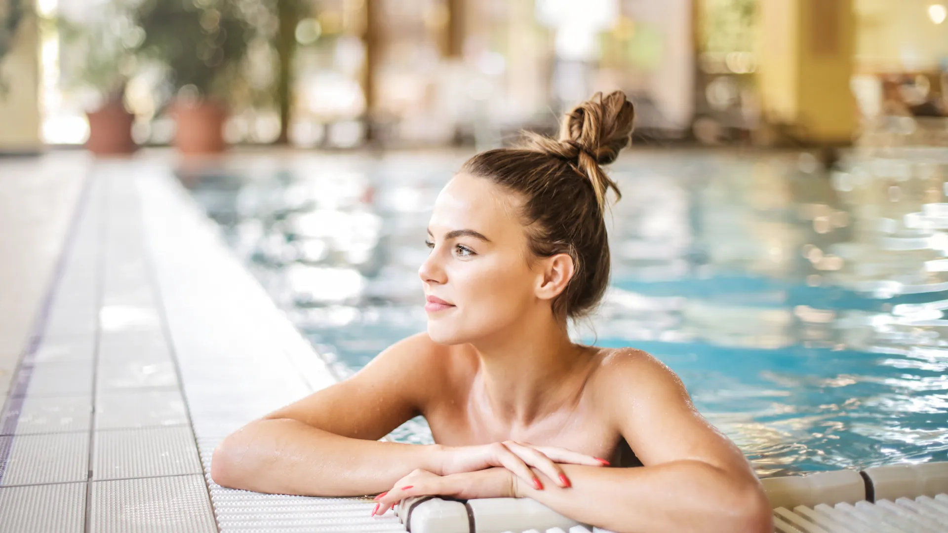 Frau im  Pool am Beckenrand