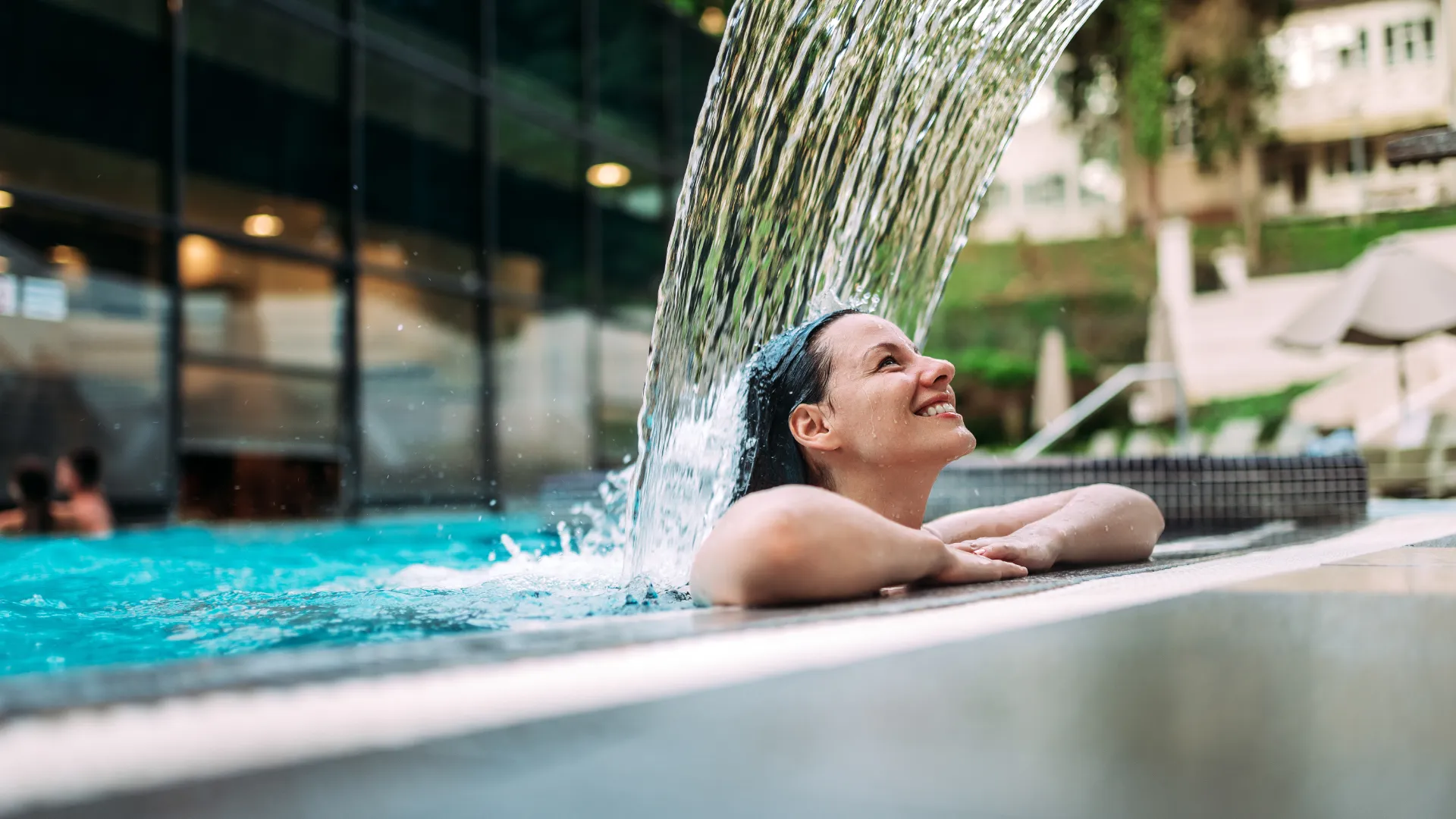 Frau im  Pool am Beckenrand