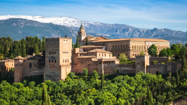 Alhambra/Außenansicht mit Bäumen und Bergen